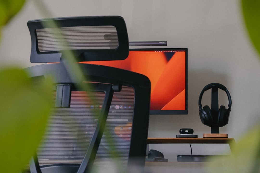 Clean minimal home office desk setup with monitor, keyboard, and desk lamp